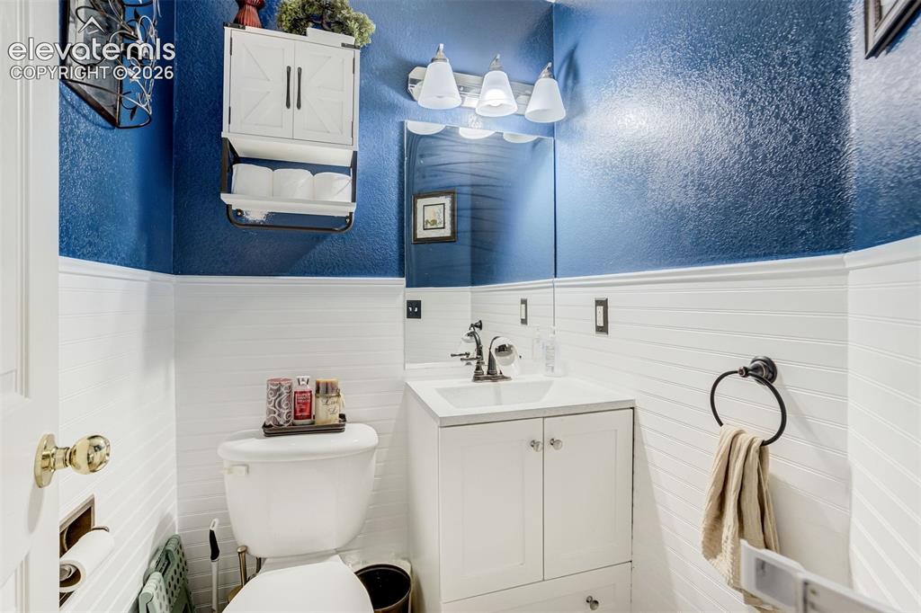 Image 17 of 43: White beadboard wainscoting with a textured blue upper wall