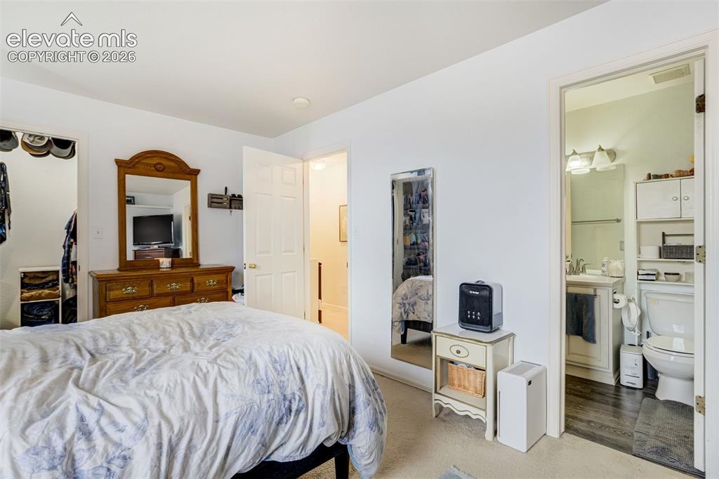 Image 22 of 43: Carpeted flooring, white walls, open doorway, built-in closet with shelving