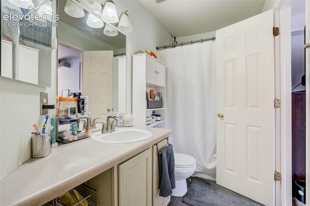 Image 24 of 43: Vanity with an integrated sink, brushed nickel faucet, and a wall-mounted l
