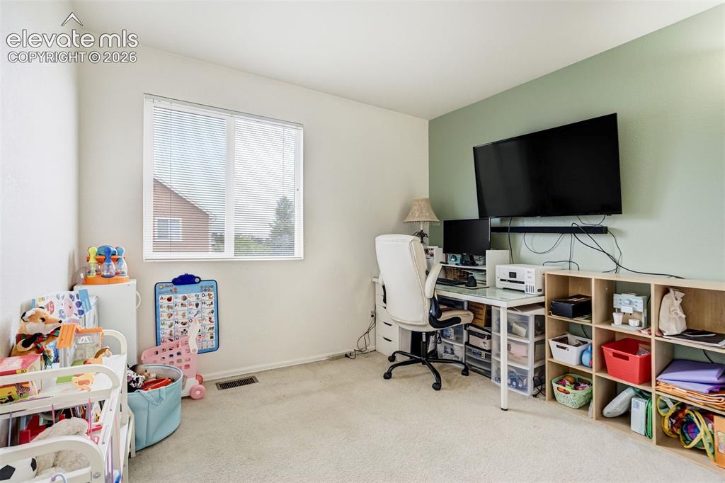Image 27 of 43: Wall-mounted television with soundbar, modern desk with a glass top, built-