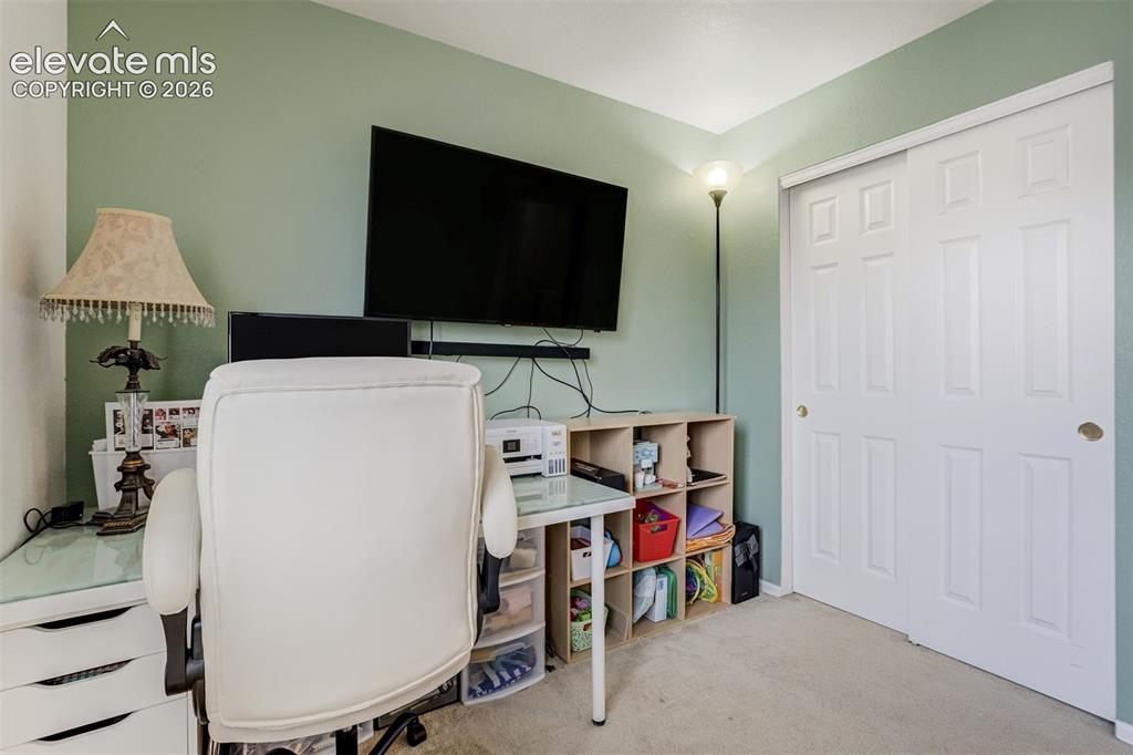 Image 28 of 43: Wall-mounted display, built-in shelving, sliding panel closet doors, and ca