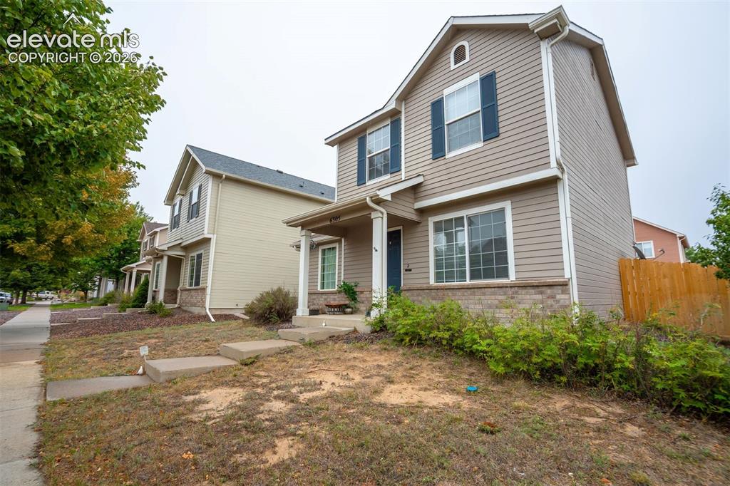Image 30 of 43: Two-story residence with horizontal siding, brick accent detailing, and dar