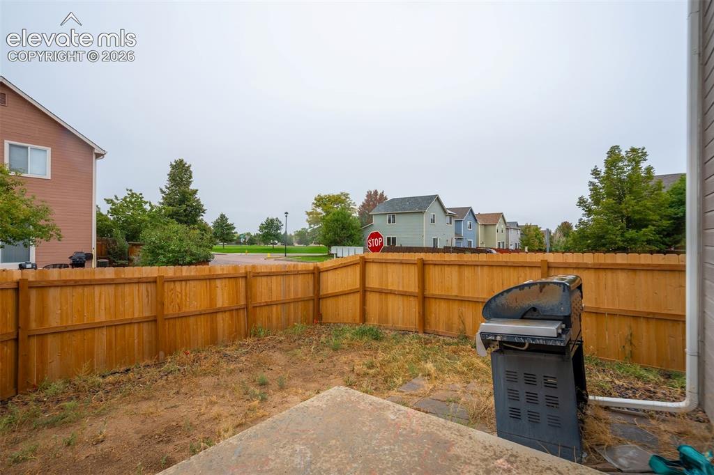 Image 32 of 43: Private backyard featuring a wood privacy fence and a concrete patio