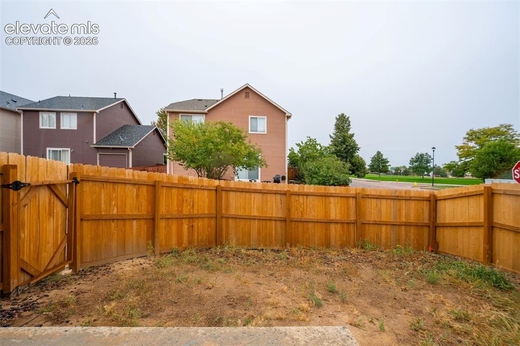 Image 33 of 43: Fenced backyard with wood privacy fencing and a gate, offering direct acces