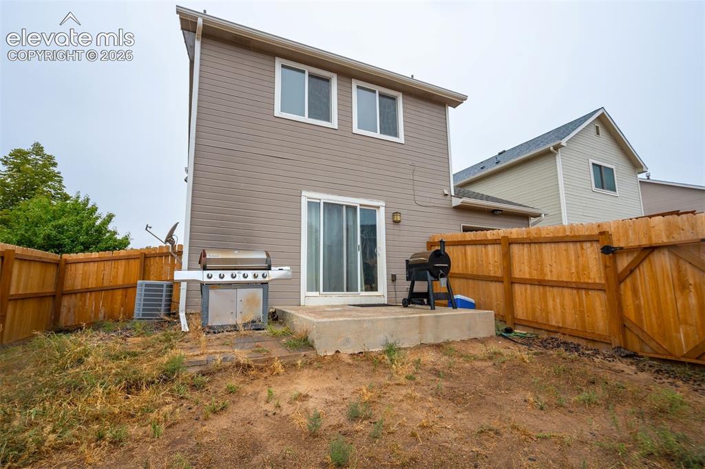 Image 34 of 43: Rear exterior with siding, two upper-level windows, a ground-level sliding