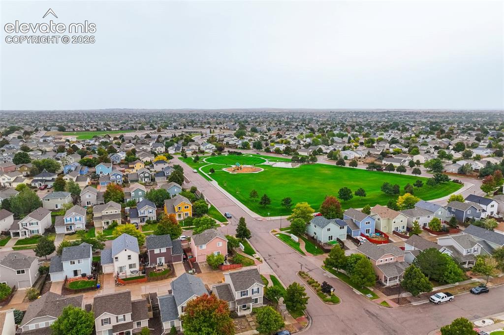 Image 41 of 43: Expansive green space featuring playground equipment, surrounded by residen