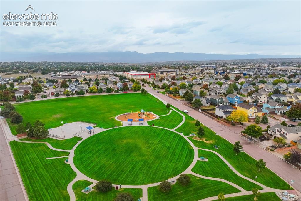 Image 5 of 43: Expansive neighborhood park featuring a large grassy area, walking paths, a