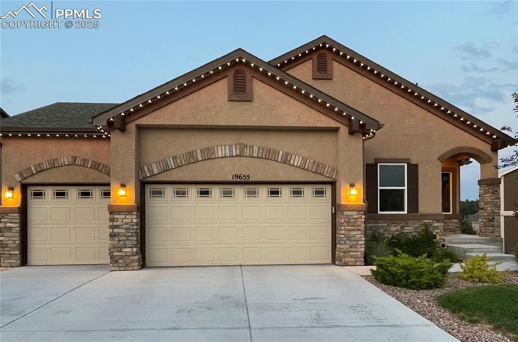 Image 1 of 47: Mediterranean / spanish home with stone siding, an attached garage, and dri