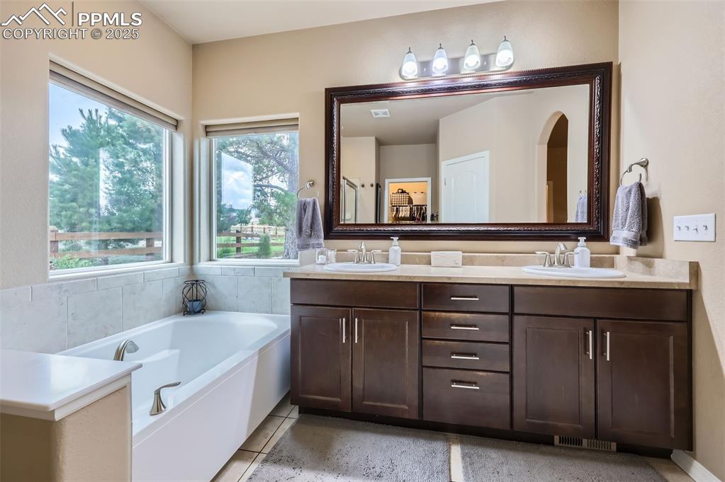 Image 17 of 47: Bathroom with double vanity and a garden tub