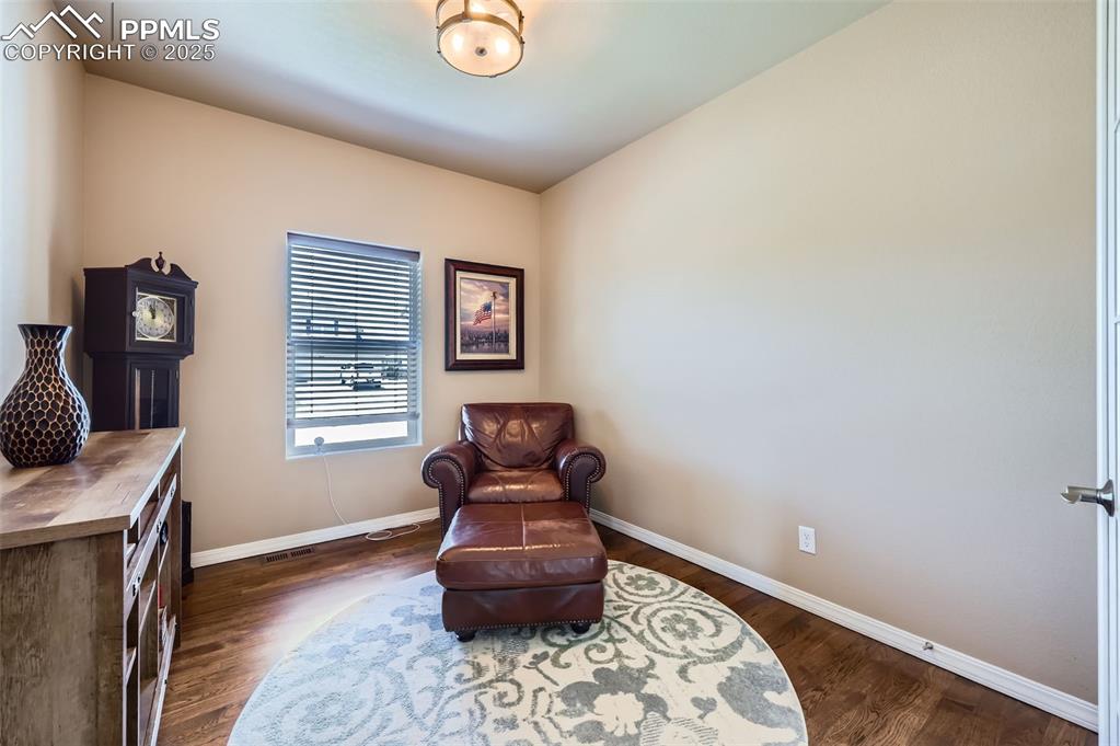 Image 18 of 47: Living area with baseboards and dark wood finished floors