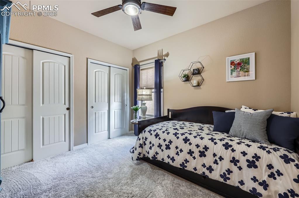 Image 19 of 47: Carpeted bedroom with two closets and ceiling fan