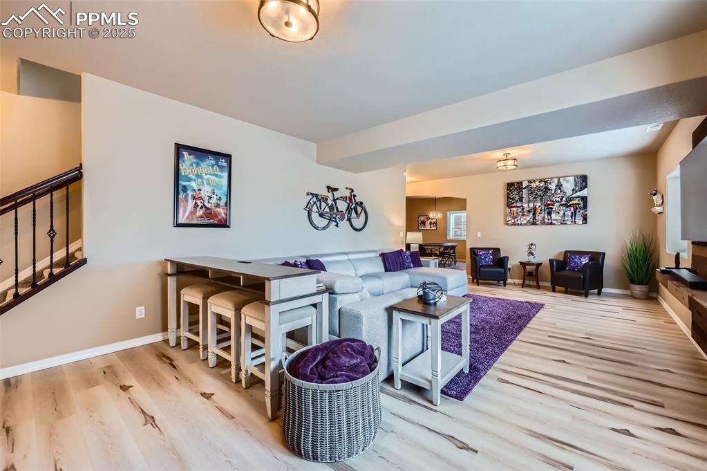 Image 21 of 47: Living room with wood finished floors and stairway