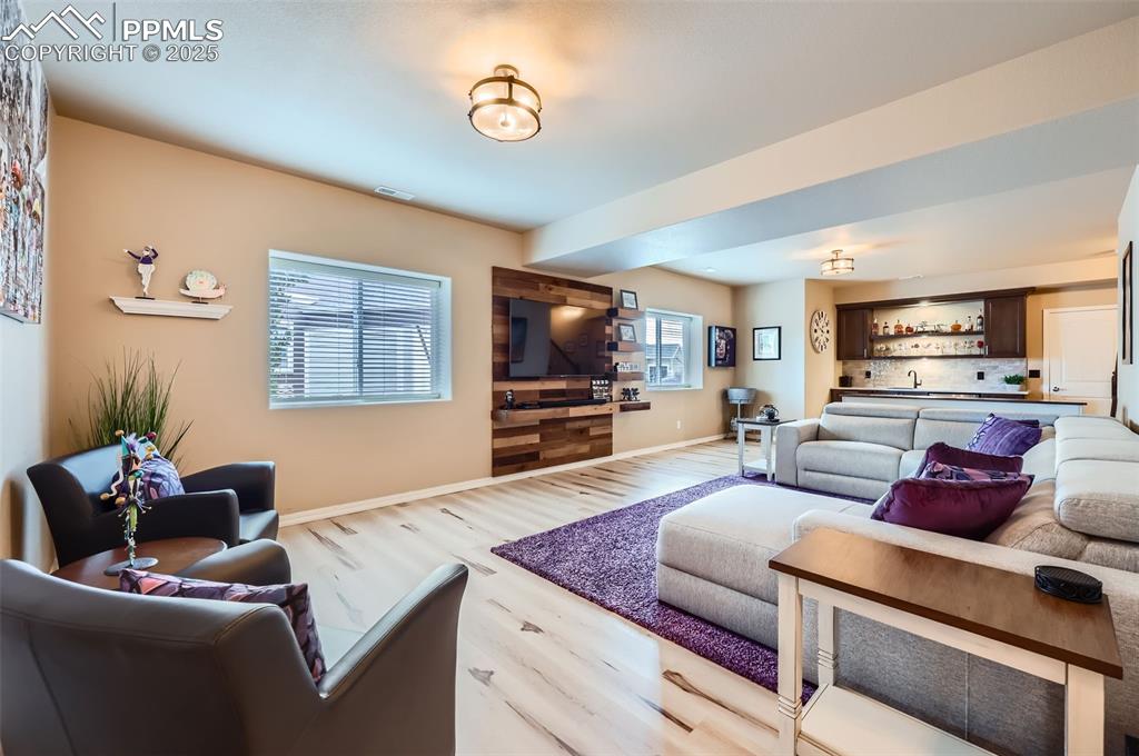 Image 23 of 47: Living room with wood finished floors and bar