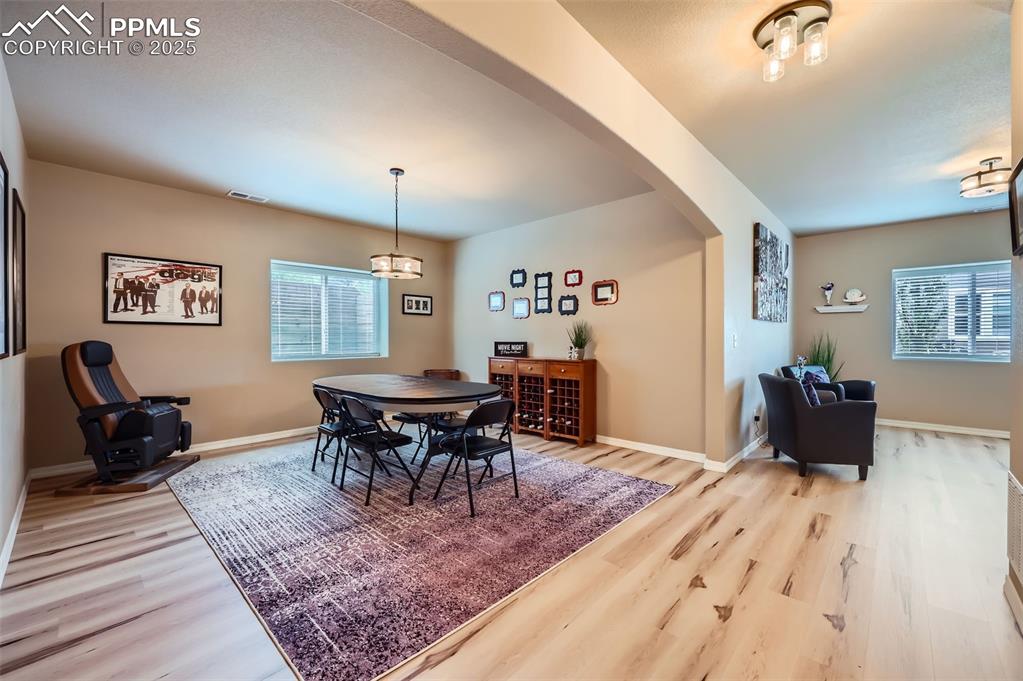 Image 24 of 47: Dining space with arched walkways and wood finished floors