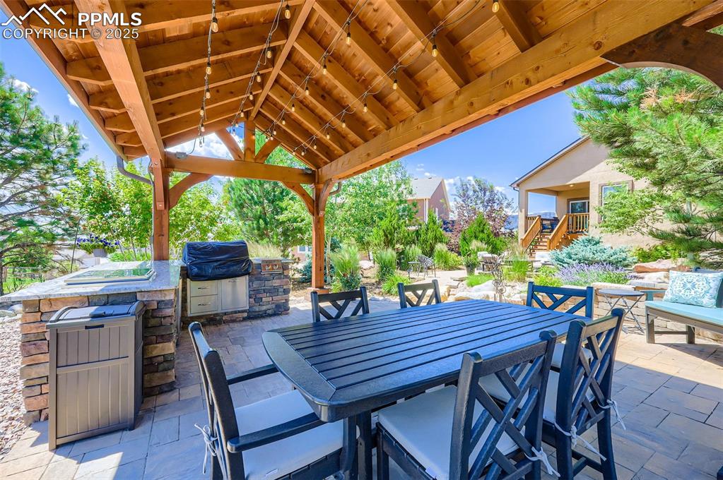 Image 44 of 47: View of patio with area for grilling, a gazebo, and an outdoor bar