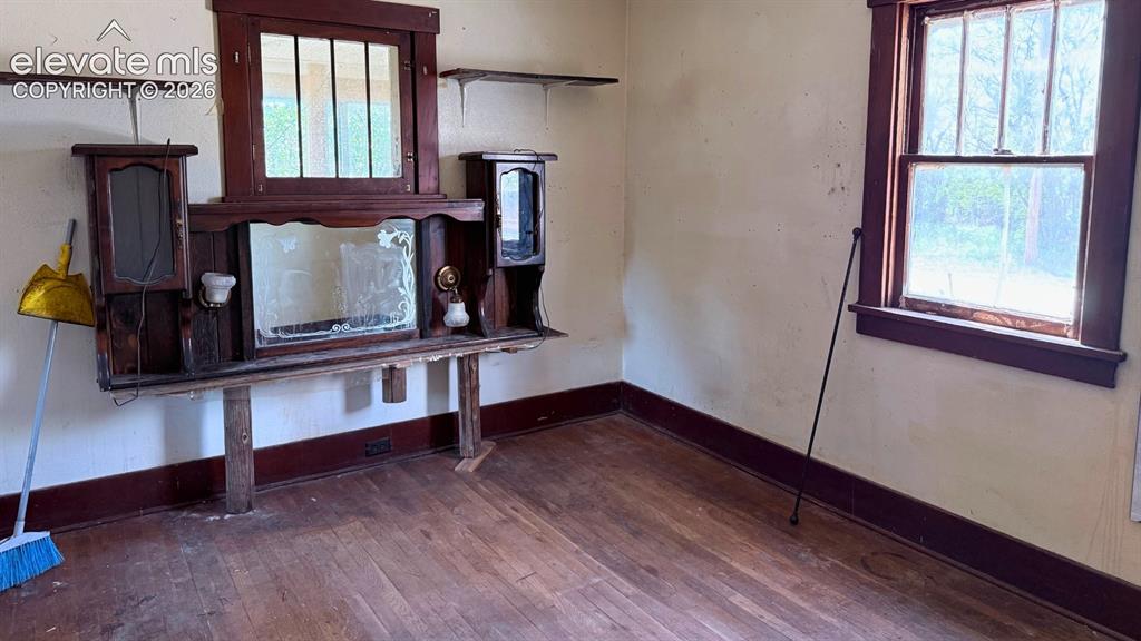 Image 10 of 13: Interior room featuring wood-panel walls, wood-finish flooring, a ceiling f