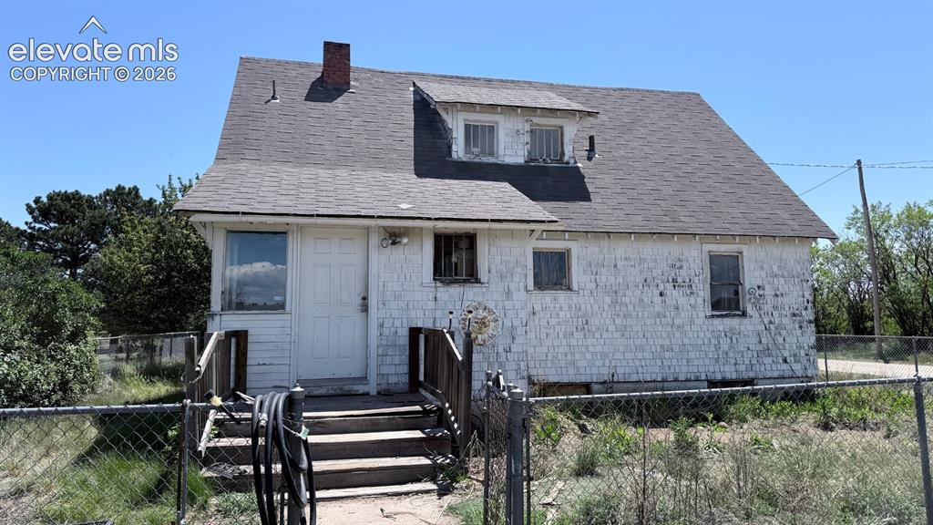 Image 8 of 9: Two-story residential structure with white shingle siding, a gray shingle r