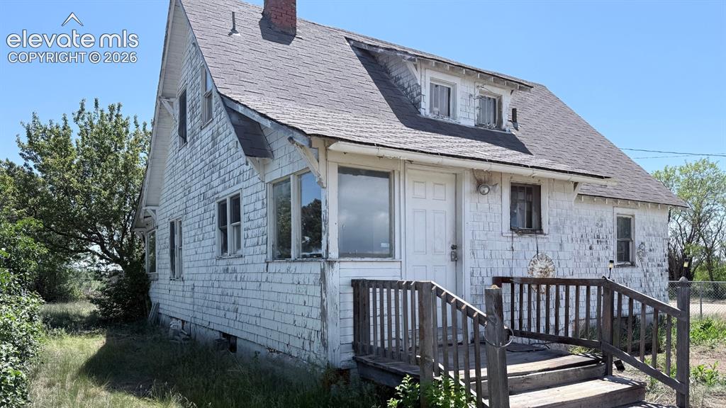 Image 9 of 9: White shingle-sided home with an asphalt shingle roof