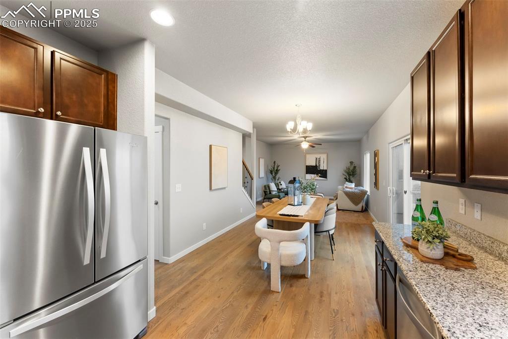 Image 12 of 50: Kitchen featuring stainless steel appliances, light wood-type flooring, lig