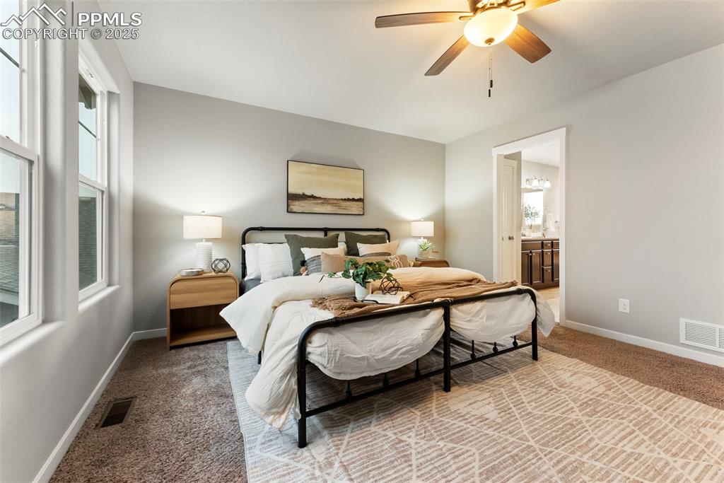 Image 17 of 50: Bedroom with carpet, a ceiling fan, and ensuite bathroom