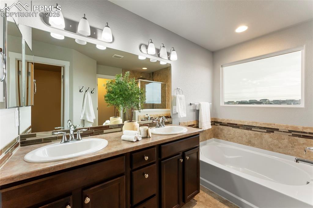 Image 20 of 50: Full bathroom featuring a stall shower, a garden tub, double vanity, and re
