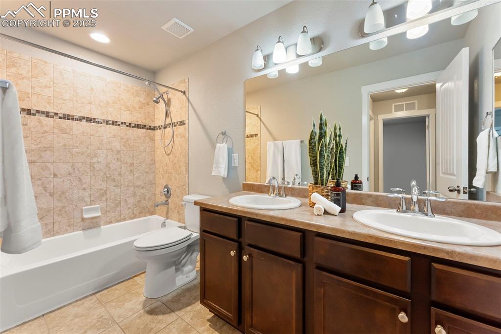 Image 26 of 50: Bathroom with shower / bath combo with shower curtain, double vanity, light
