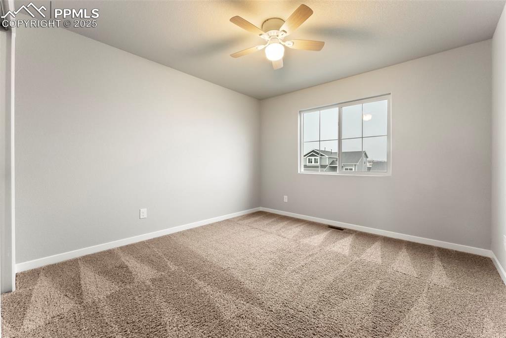 Image 27 of 50: Empty room featuring carpet floors and a ceiling fan