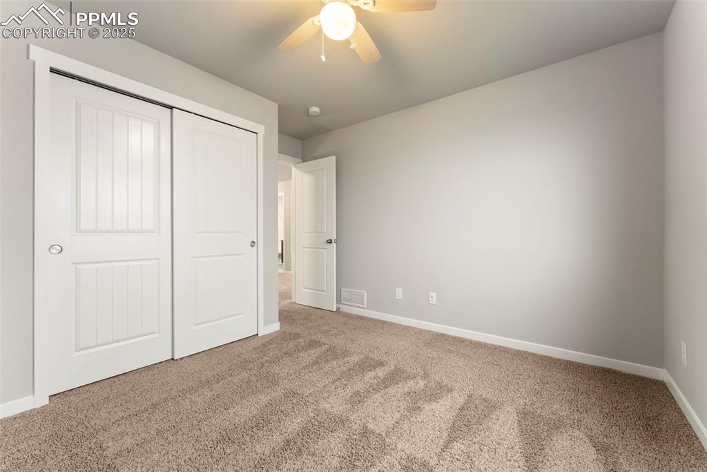 Image 29 of 50: Unfurnished bedroom featuring carpet floors, a closet, and a ceiling fan
