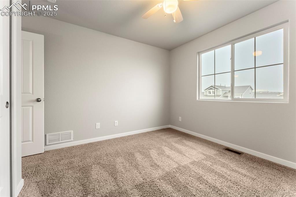 Image 30 of 50: Carpeted spare room with baseboards and a ceiling fan