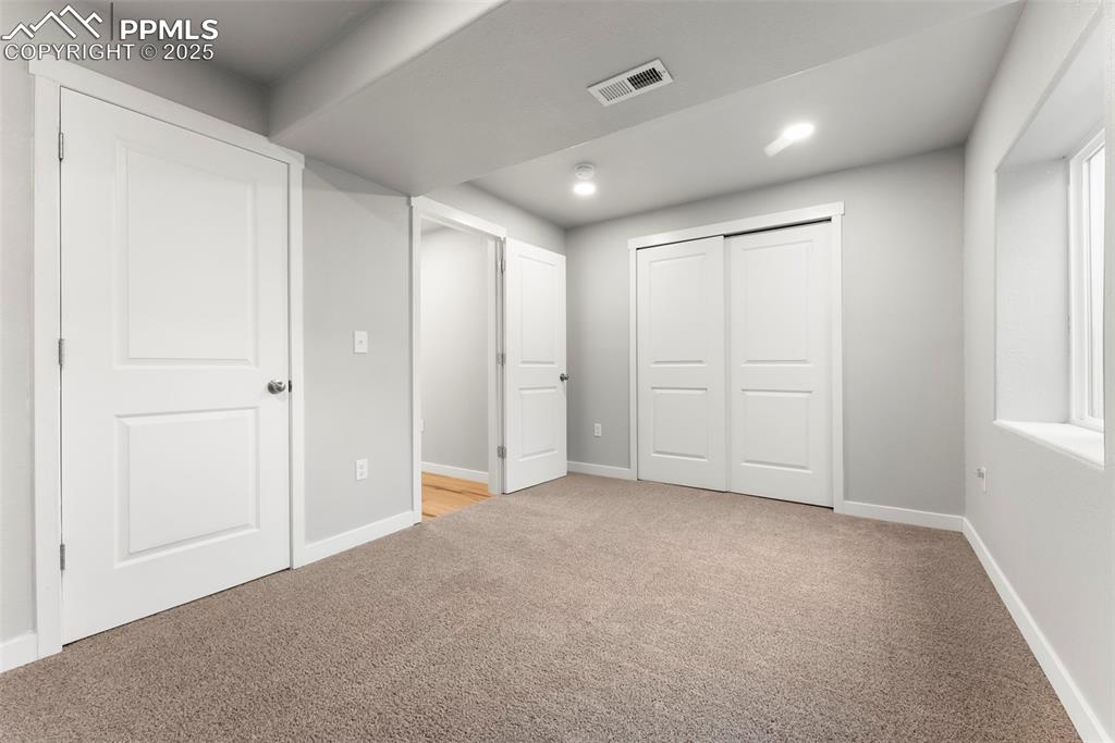 Image 36 of 50: Unfurnished bedroom featuring light carpet and recessed lighting