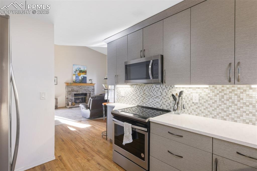 Image 13 of 31: Hardwood floors flow from the entryway into the kitchen.