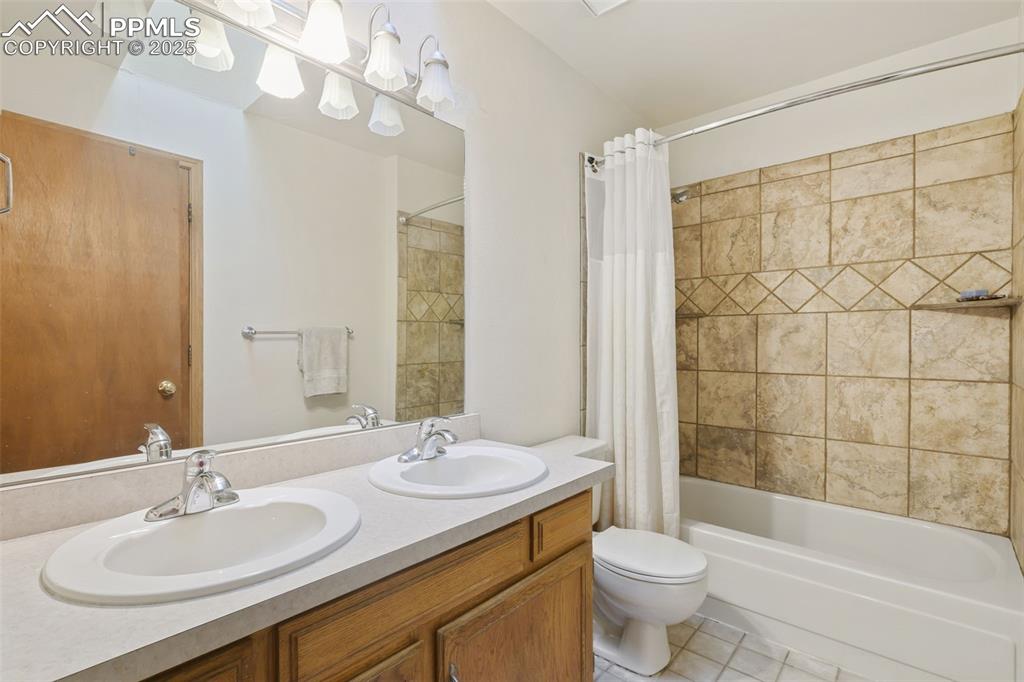 Image 17 of 31: Upper level full bath boasts a double vanity, tiled tub/shower surround and