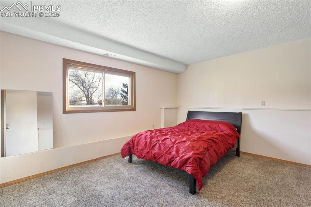 Image 23 of 31: Lower level bedroom is adjacent to family room.