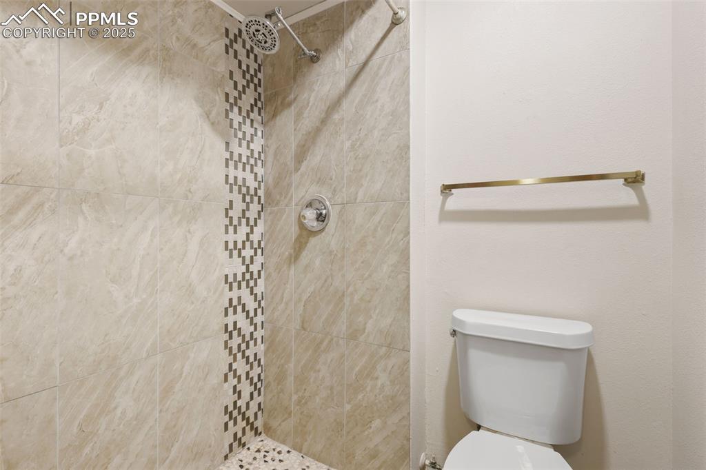 Image 26 of 31: The lower level 3/4 bath features a beautiful, tiled shower.