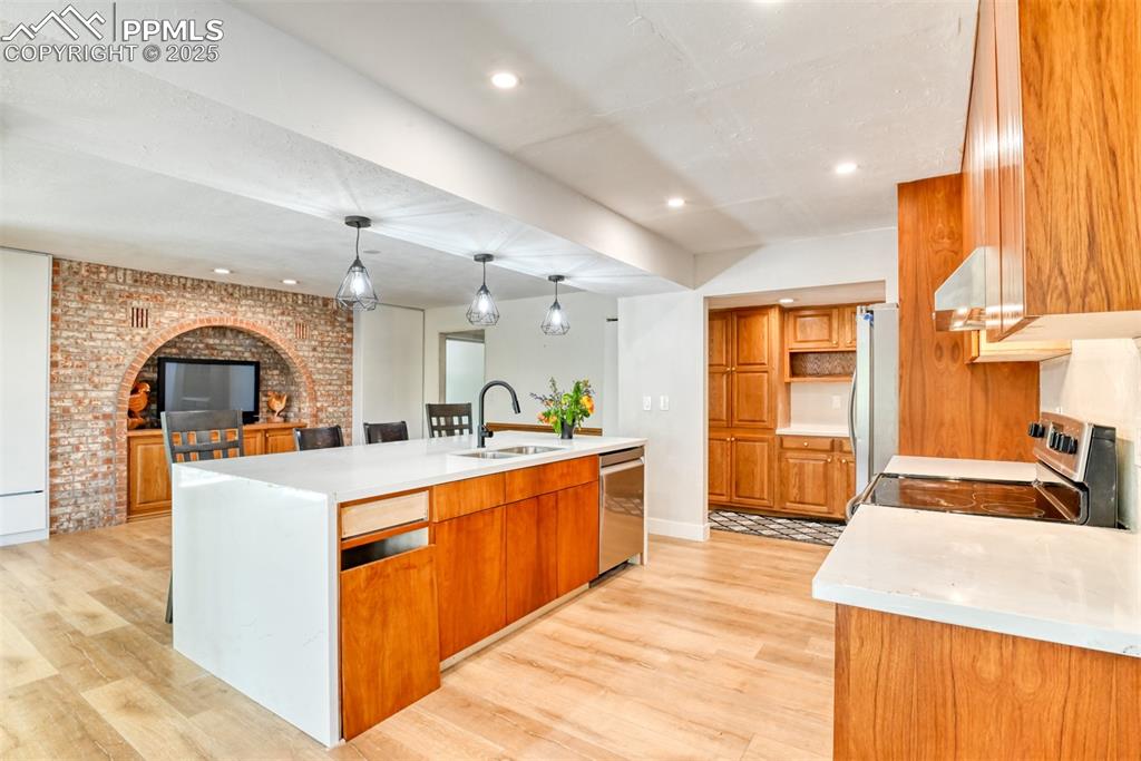 Image 11 of 50: Kitchen featuring a sink, appliances with stainless steel finishes, an isla