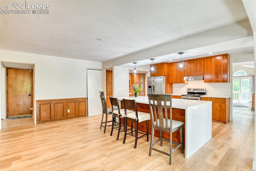 Image 12 of 50: Kitchen with stainless steel appliances, extractor fan, light wood-style fl