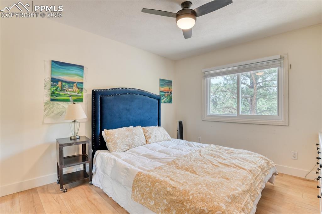 Image 28 of 50: Bedroom with baseboards, wood finished floors, and ceiling fan