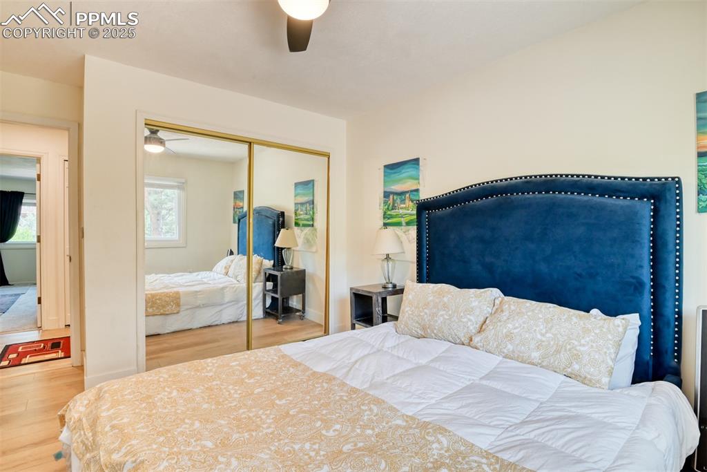 Image 30 of 50: Bedroom with wood finished floors, a closet, and a ceiling fan