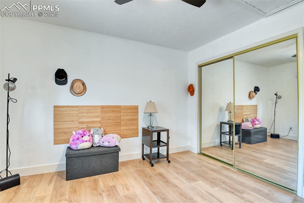 Image 32 of 50: Living area with ceiling fan, wood finished floors, and baseboards