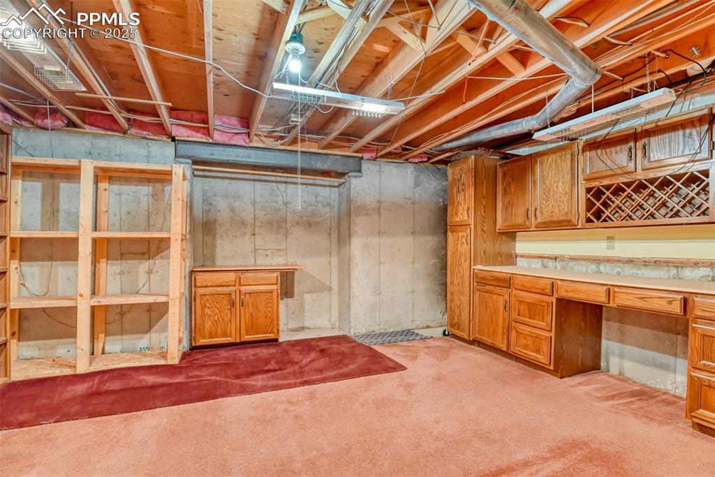 Image 39 of 50: Plentiful basement storage room featuring carpet floors and an office area
