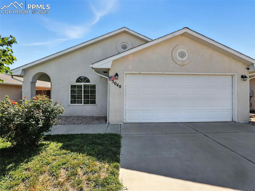 Caption: Front exterior, stucco, 2 car garage