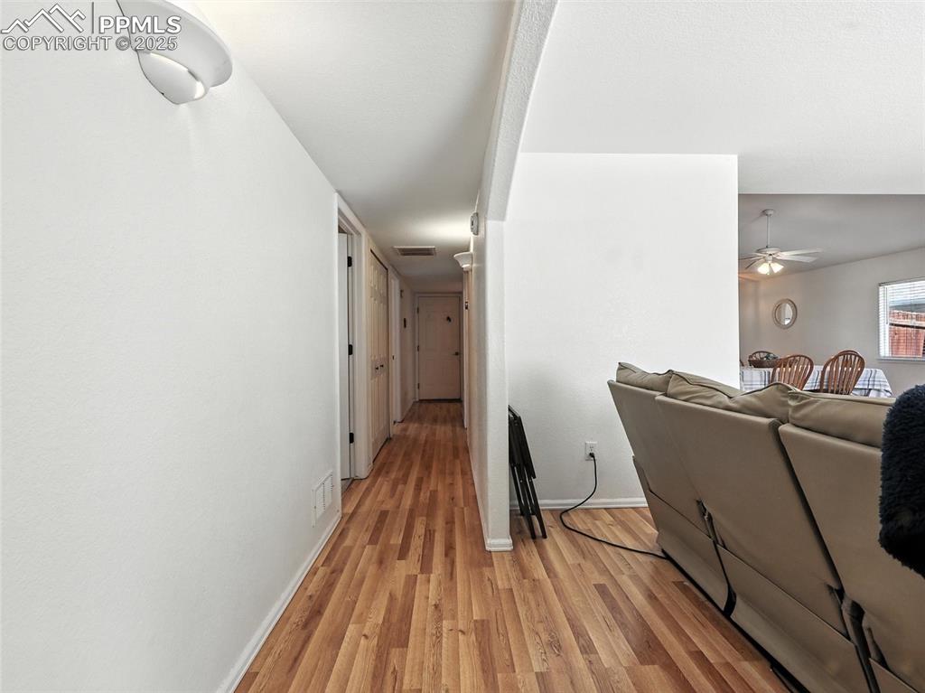 Image 22 of 38: hallway - access to secondary bedrooms, main bath and garage at end of hall