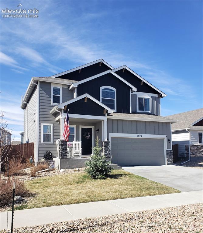 Caption: Contemporary two-story residence featuring a multi-gable roofline, a covered porch with stone-clad c