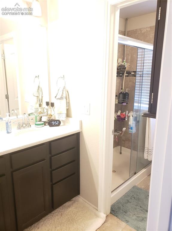 Image 13 of 34: Bathroom vanity with a white countertop and dark cabinetry