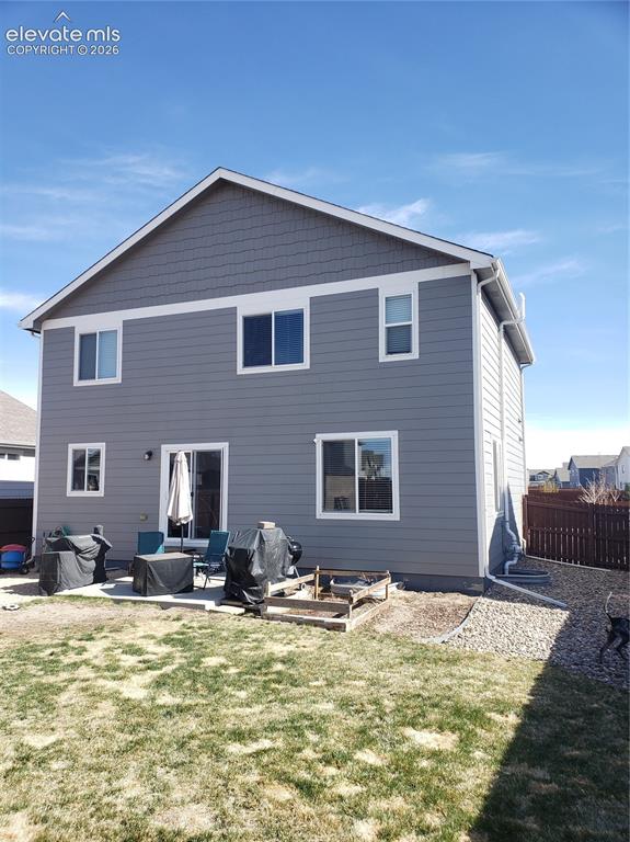 Image 17 of 34: Spacious backyard featuring a concrete patio, a raised garden bed, and a gr