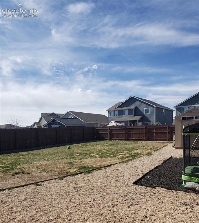 Image 18 of 34: Expansive backyard featuring a privacy fence, a large patch of natural gras