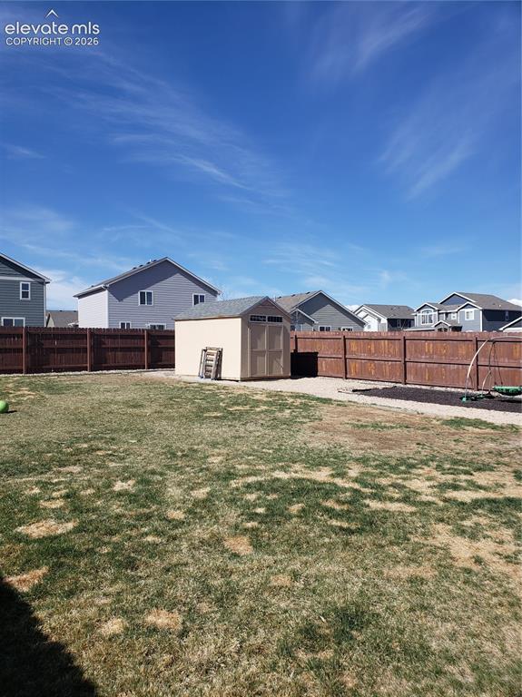 Image 19 of 34: Expansive backyard featuring a storage shed with a shingled roof, a full wo