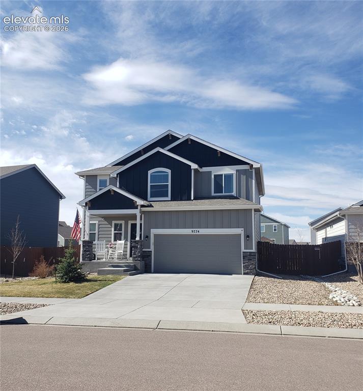 Image 2 of 34: Two-story property featuring a multi-tone exterior with gray siding and dar