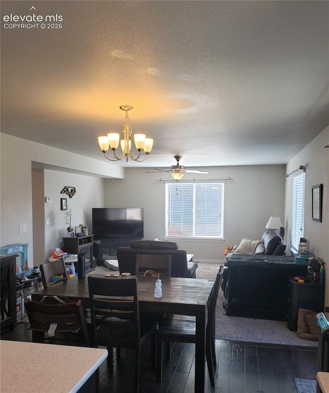 Image 30 of 34: Open-concept living area featuring a dining space with dark wood-finish flo