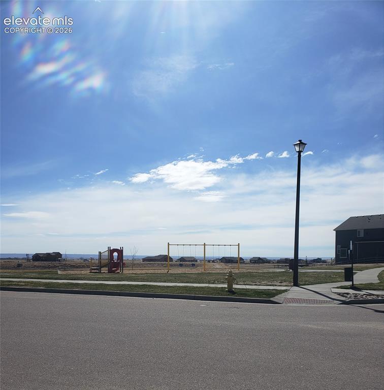 Image 34 of 34: Expansive open space featuring a red and yellow playground structure and sw